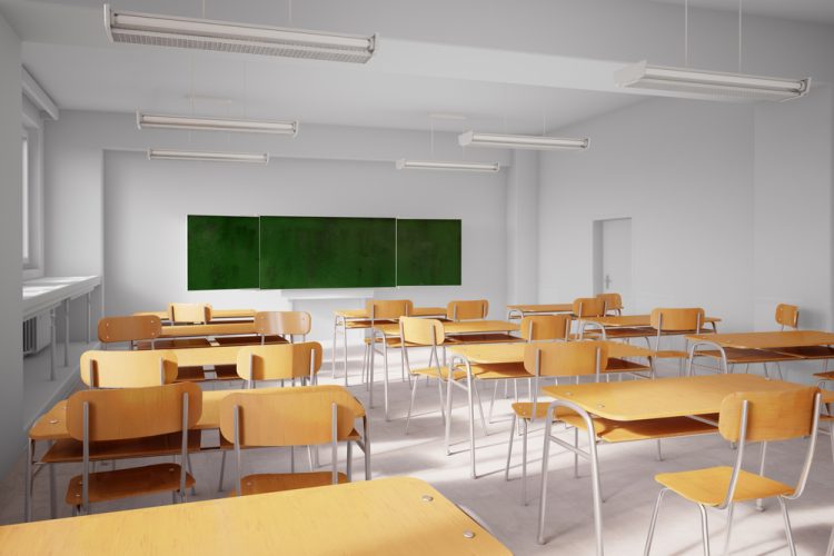 Old school classroom with wooden seats and tables