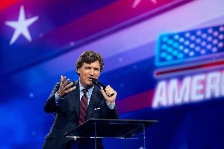 Tucker Carlson speaks as conservative leaders and personalities attend Turning Point USA's AmericaFest 2023 in Phoenix, Arizona, U.S. December 18, 2023.  REUTERS/Caitlin O’Hara/File Photo